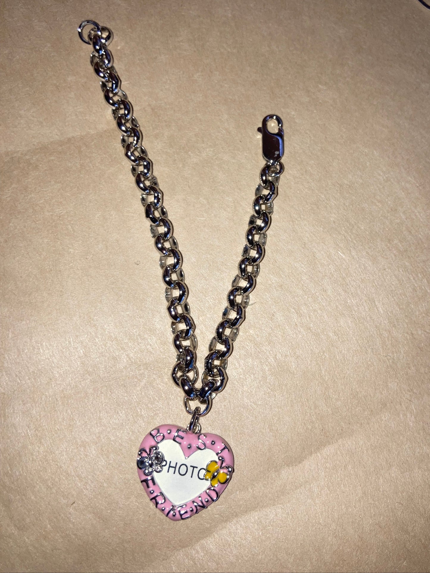 Bracelet with a heart-shaped Charm on a beige background