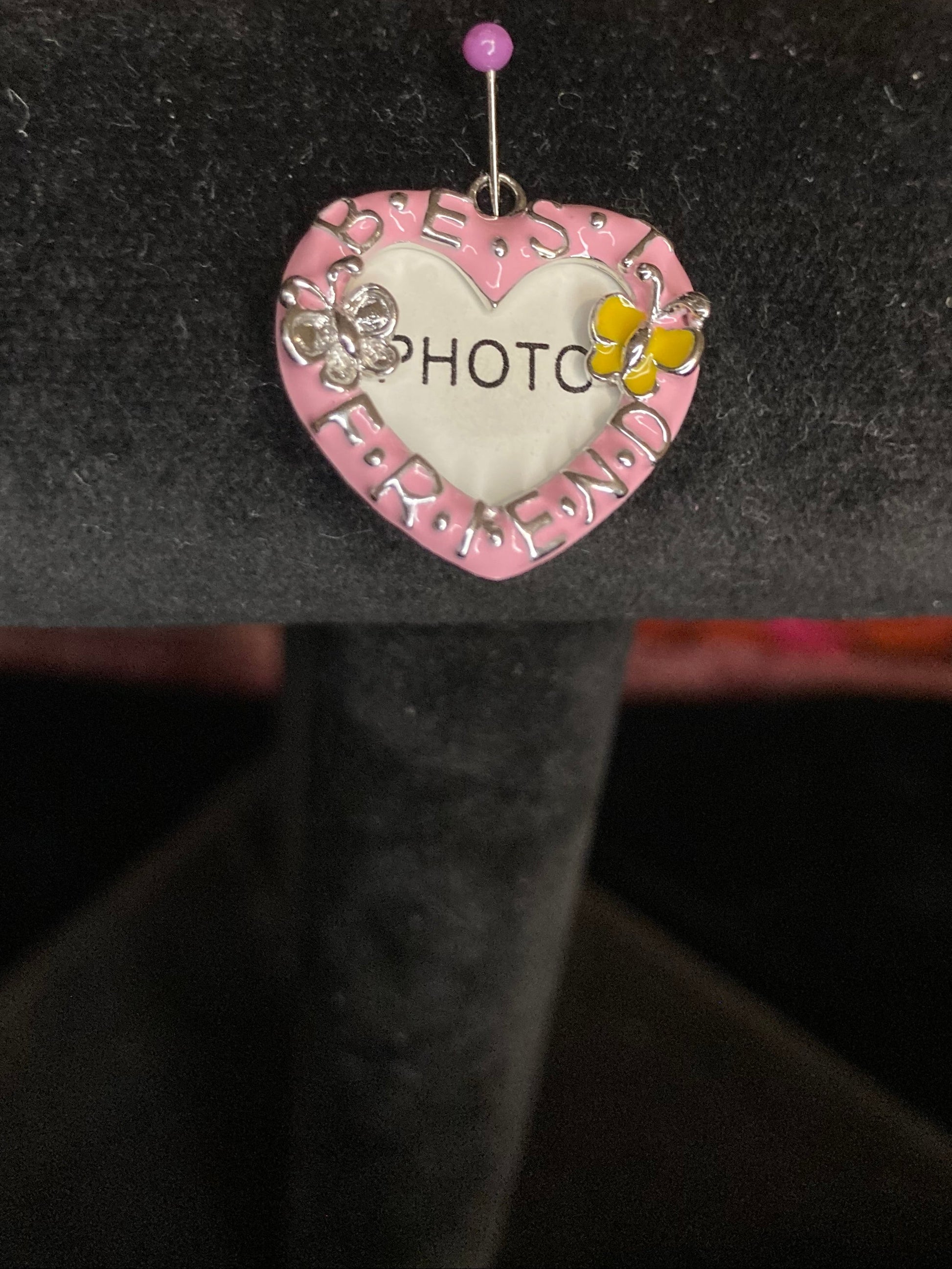 Pink photo charm on a black background