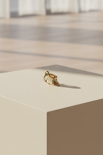 Tiny Silver Baby Bootie on a beige cube