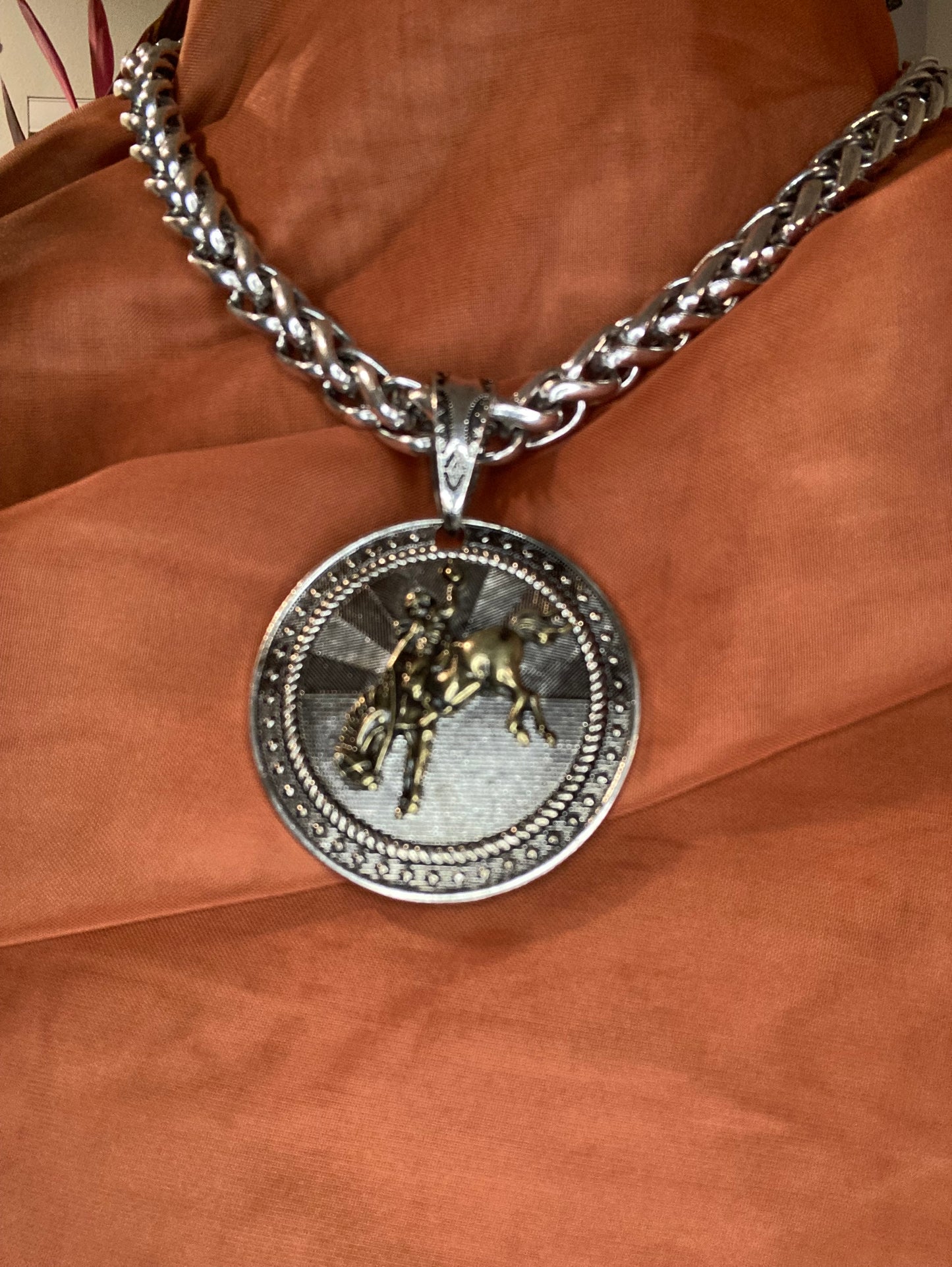 Pendant with Bucking Bronco 18 in on Brown cloth.
