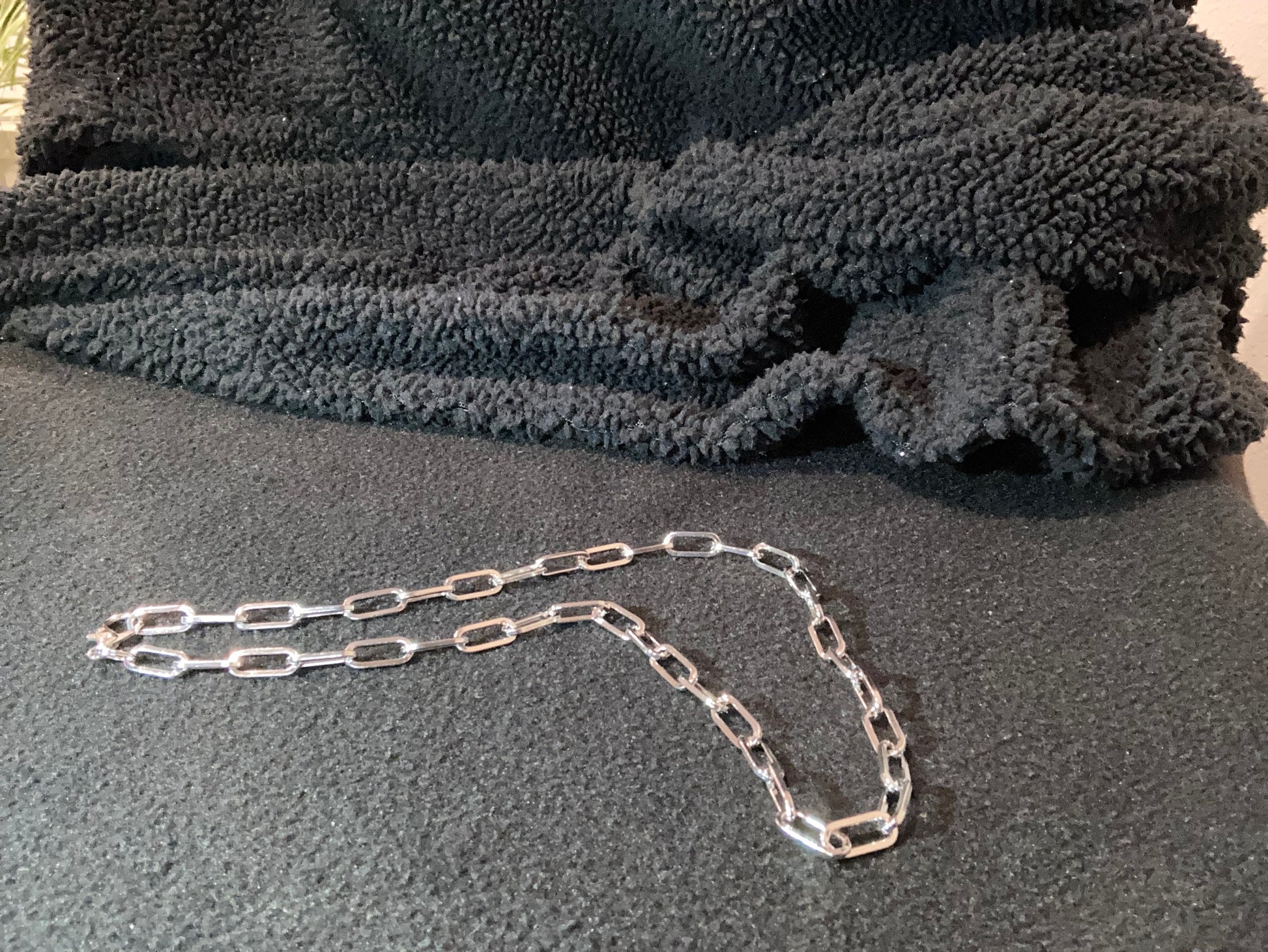 Silver-plated chain on a textured gray surface