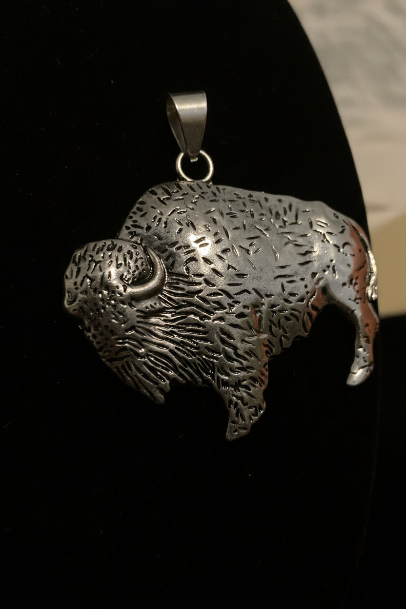 Silver Buffalo shaped pendant on a black background