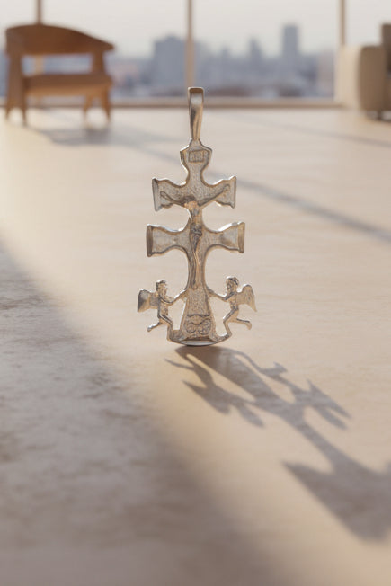 Silver Cross with angles pendant/charm on a cream background