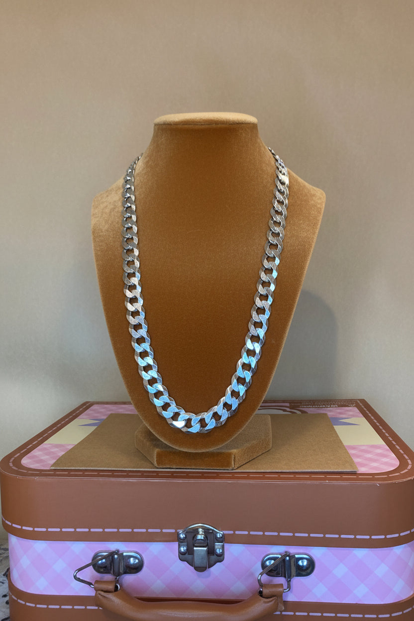 Silver chain on a carmel velvet stand with a pink jewelry box in the background.