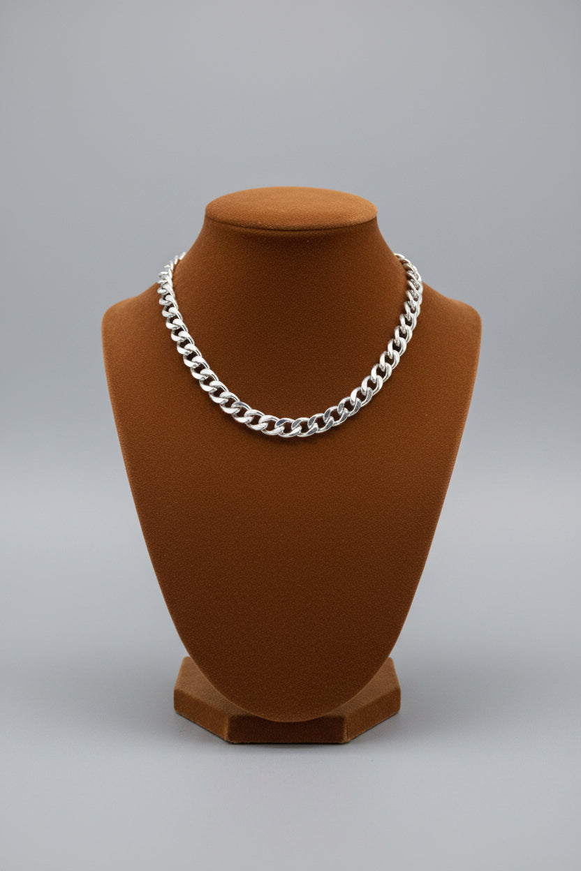 Silver Bracelet on a beige surface next to a pink and brown suite case.