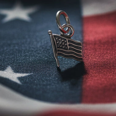 Silver flag charm on a red white and blue