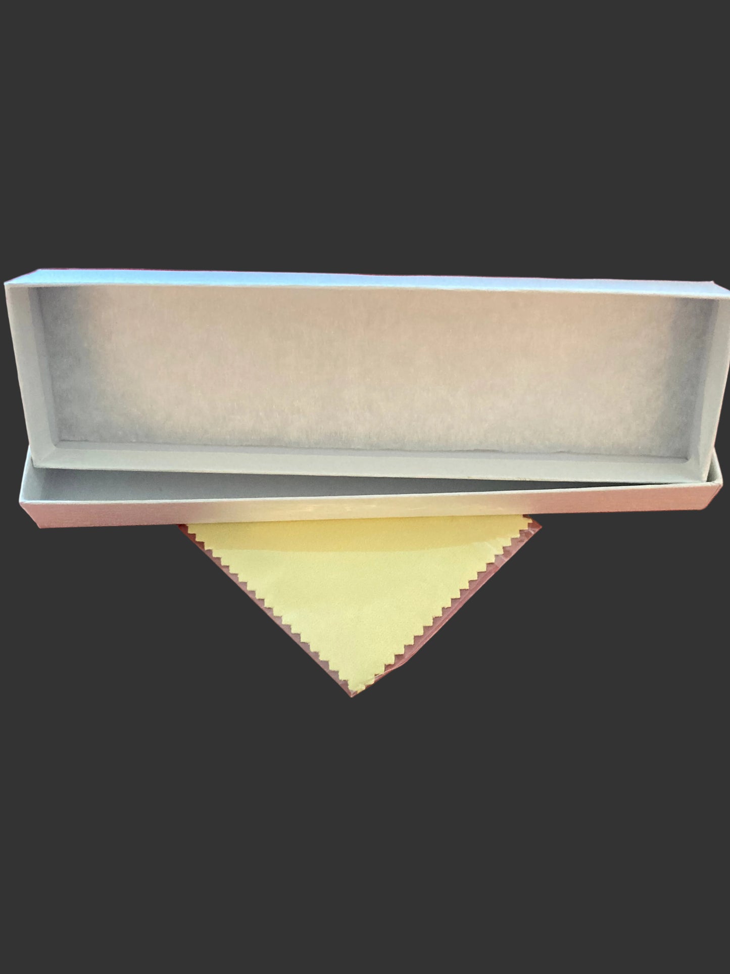 White rectangular box with a yellow cloth on a red fabric background