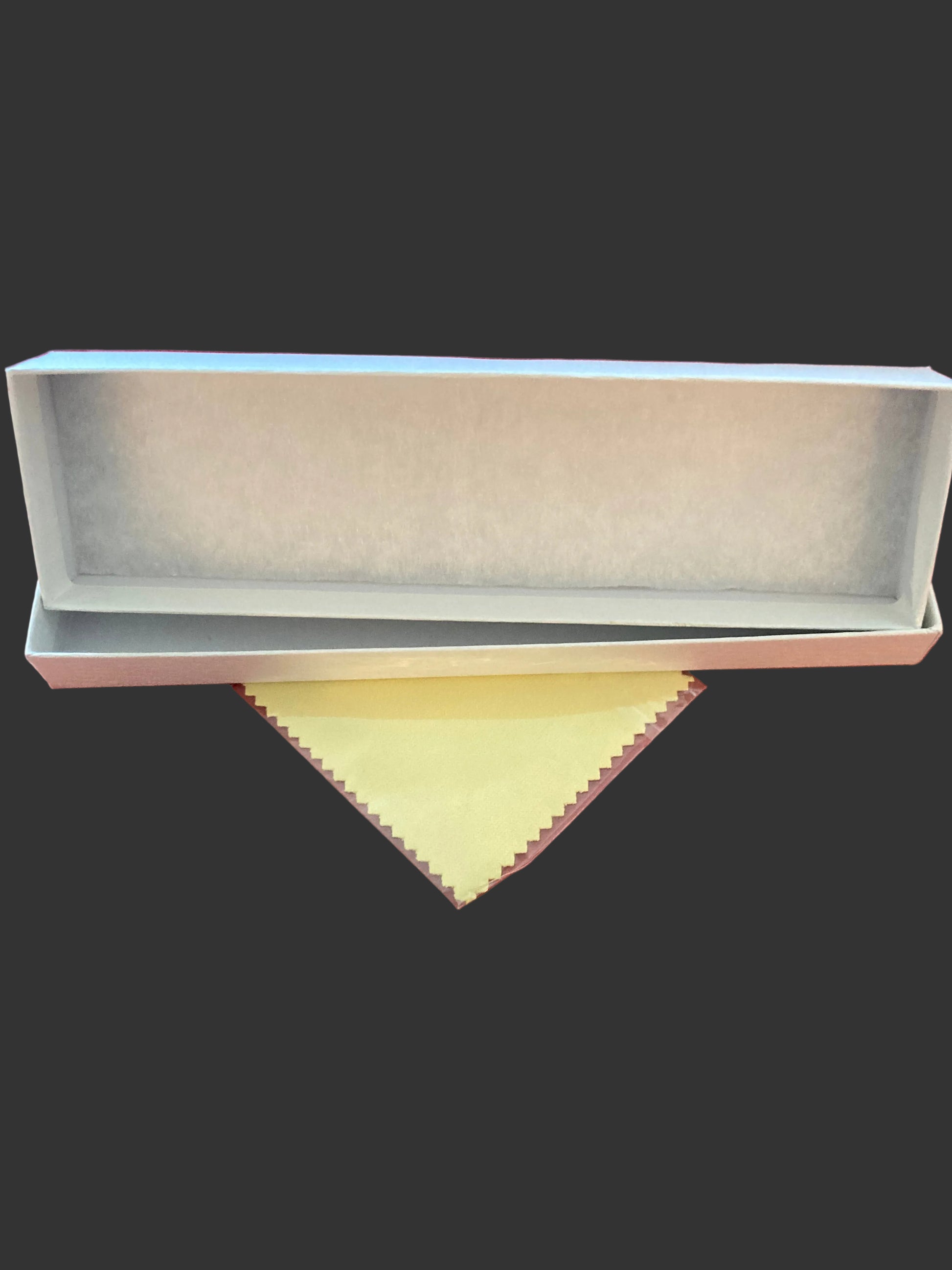 White rectangular box with a yellow cloth on a red fabric background