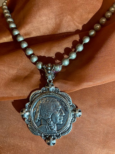 Silver-Plated  pendant with a coin design on a bronze fabric background