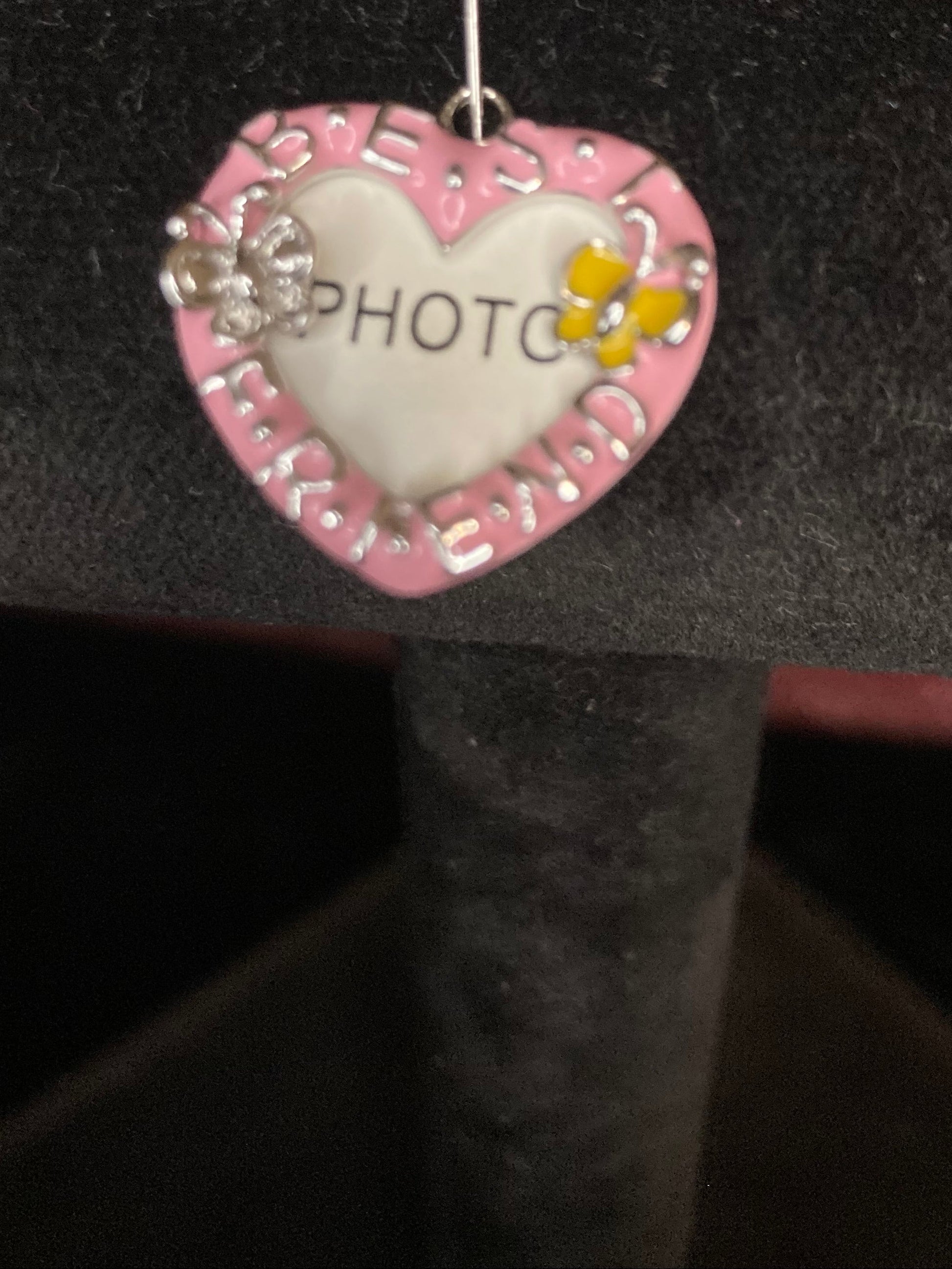 Heart-shaped decorative charm with 'PHOTO' on a black background