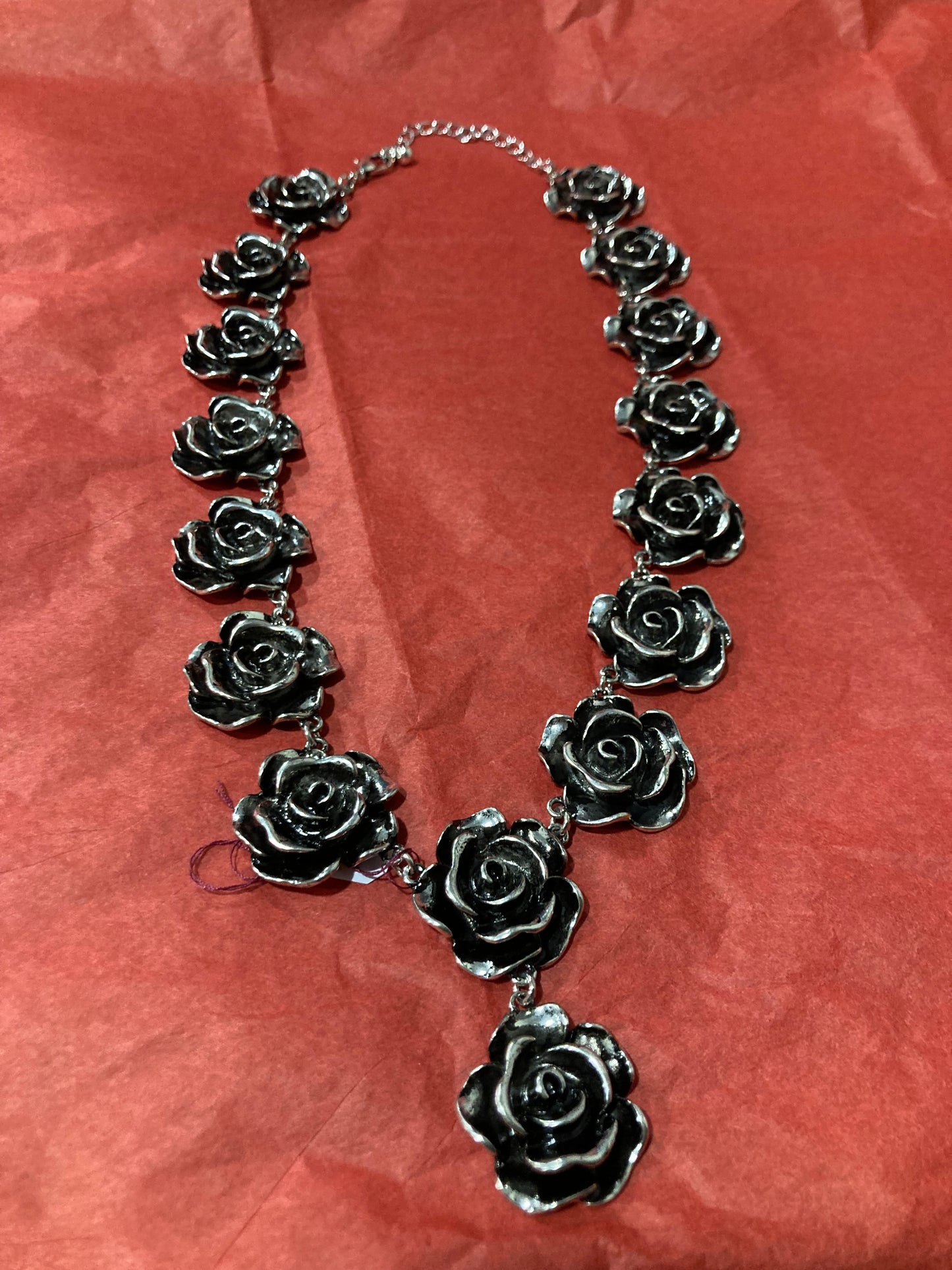 Silver-Plated rose-shaped Necklace on a red background