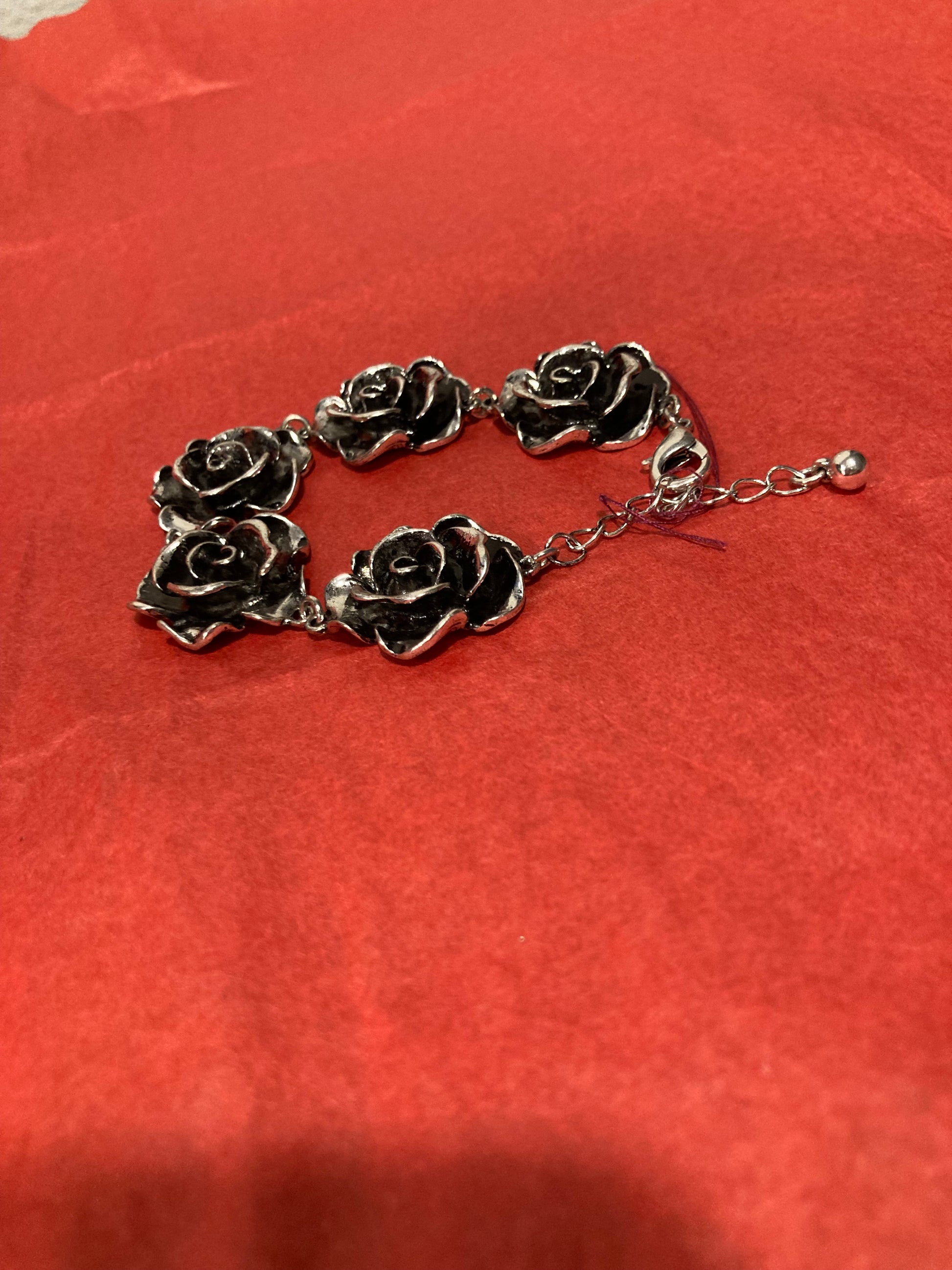 Silver rose-shaped bracelet on a red background