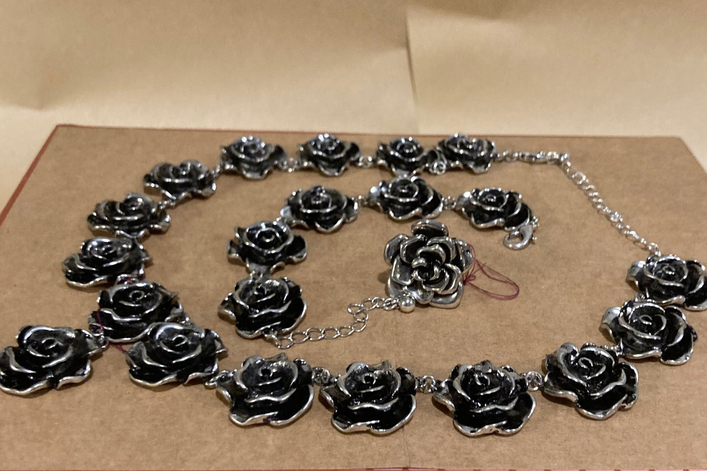 Black rose jewelry set on a pink and brown background