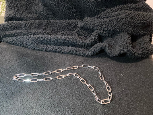 Silver-Plated Paperclip style chain on a textured gray surface