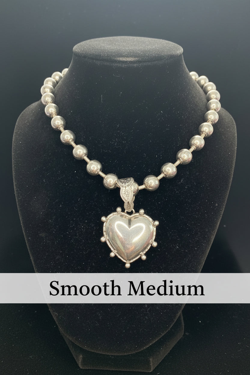 Silver necklace with a heart-shaped  Medallion on a  stand