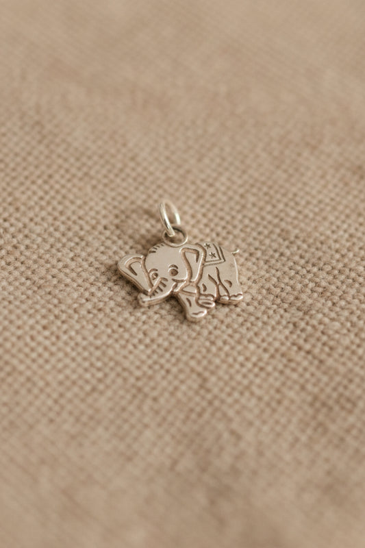 Silver elephant charm on a black background