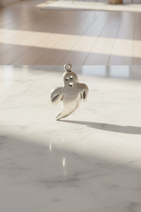 Silver ghost charm on a light background