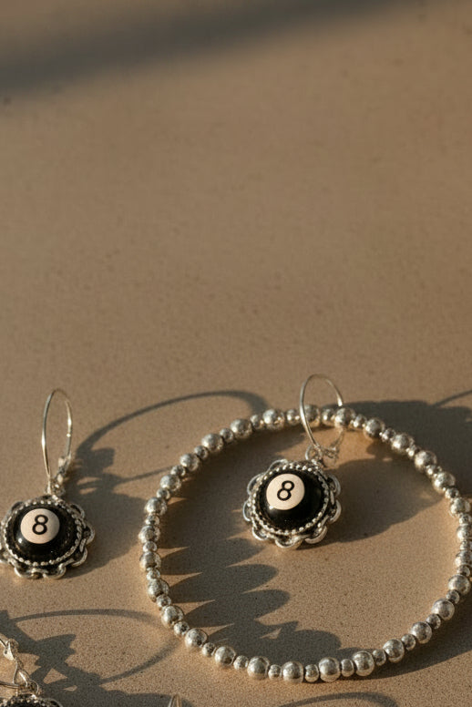 Silver plated bracelet with matching earrings on a grey background