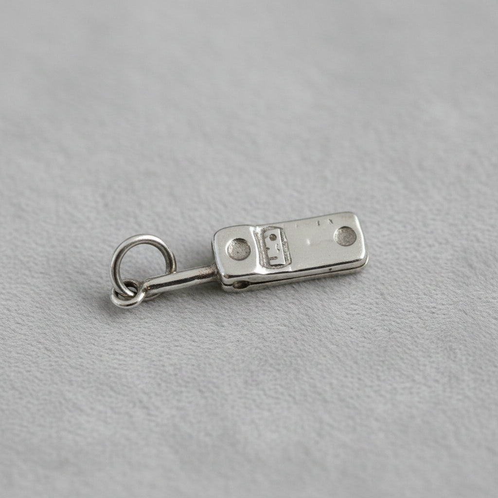 Close-up of a quilted white background with a silver cell phone charm