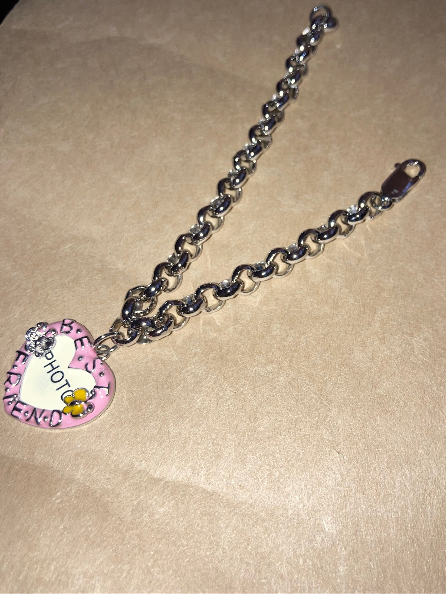 Bracelet with a heart-shaped charm on a beige background