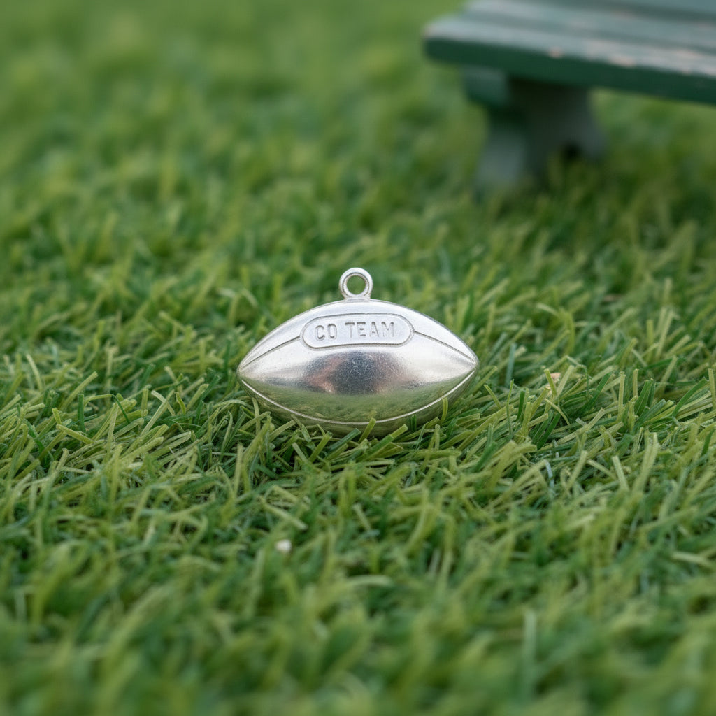 Silver football-shaped pendant on a grass background