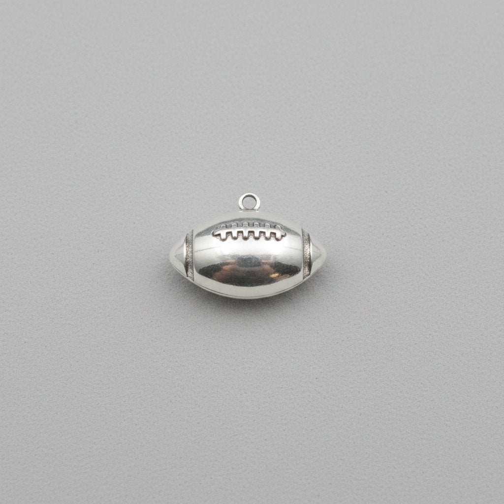 Silver football pendant/Charm on a Beige background